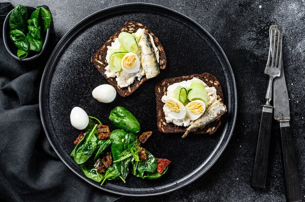 Delicious appetizer tapas, soft boiled eggs and canned sardines sandwiches.