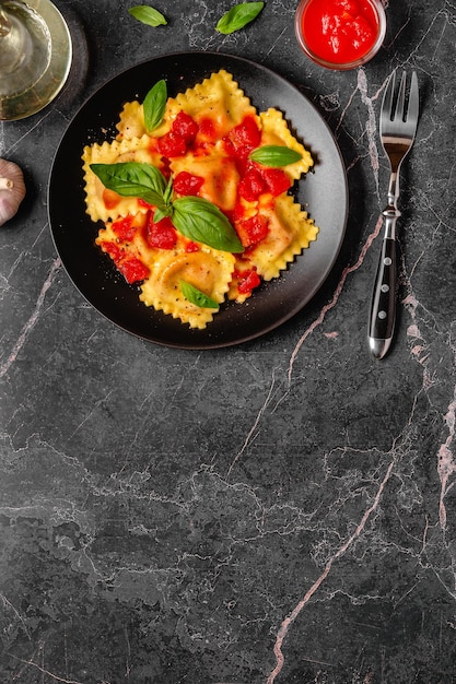 Delicious appetizing ravioli with tomato sauce and basil Top view