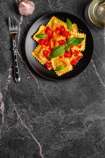 Foto deliziosi ravioli appetitosi con salsa di pomodoro e basilico vista dall'alto