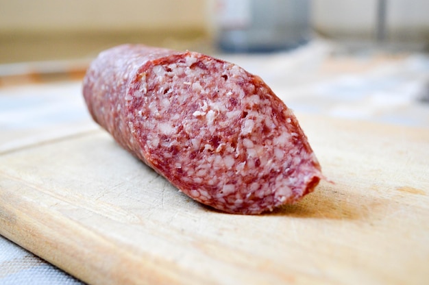 Delicious appetizing red sausage salami on a birch cutting board