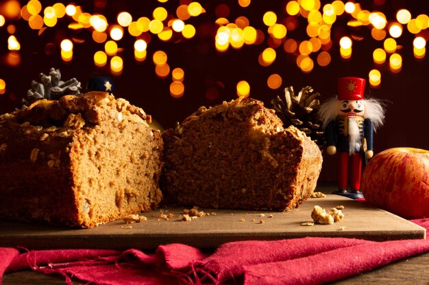 ボケ味のライトとクリスマスの装飾が施された木のテーブルにおいしいリンゴとオーツ麦のクリスマス ケーキ