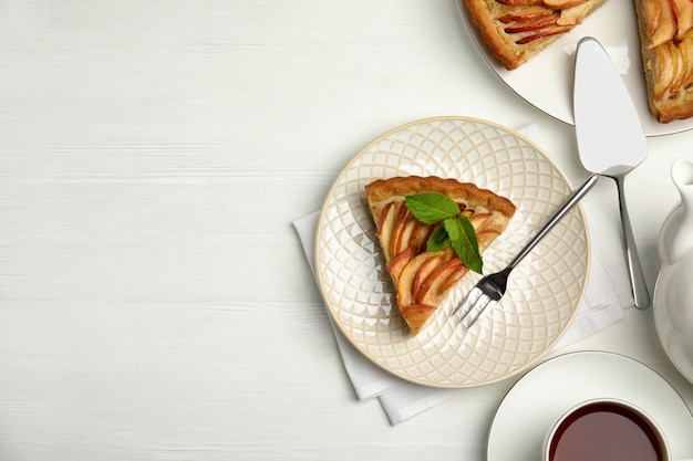 Delicious apple pie served on white wooden table flat lay Space for text