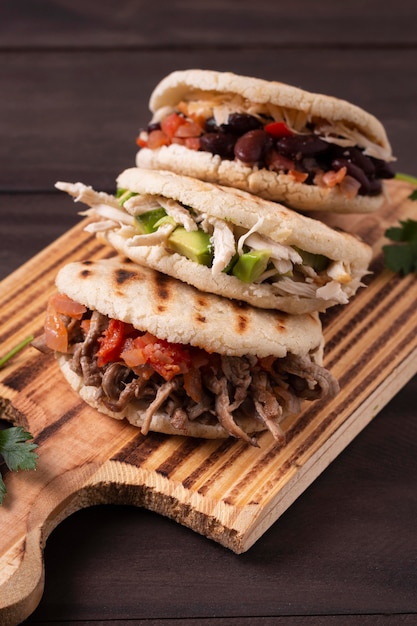 Delicious arepas on wooden board high angle