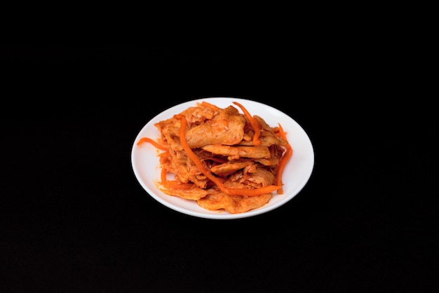 Delicious asian soy vegan meat salad on white plate on black background Selective focus Asian food concept