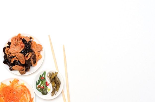 젓가락과 흰색 배경에 있는 맛있는 아시아의 다양한 샐러드 선택적 초점 아시아 음식 개념