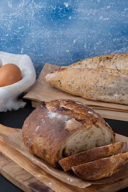 Delicious baked breads on cutting board.