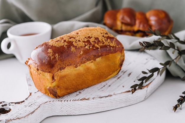 Delicious baked bun on white wood