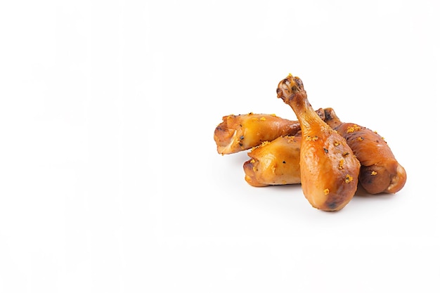 Delicious baked chicken drumsticks in honeymustard marinade isolated on white background