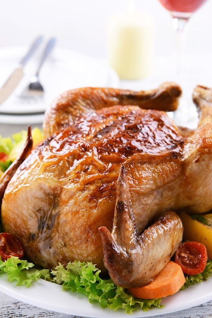 Delicious baked chicken on plate on table on light surface