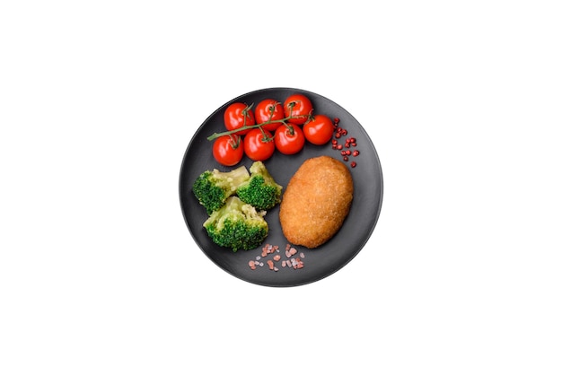 Delicious baked cutlet breaded with spices salt and herbs on a dark concrete background