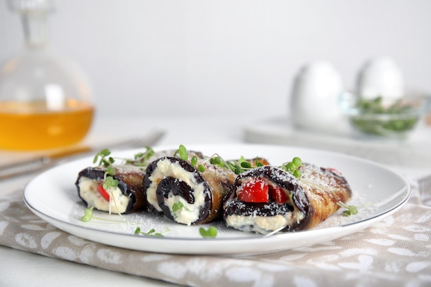 Delicious baked eggplant rolls served on white table