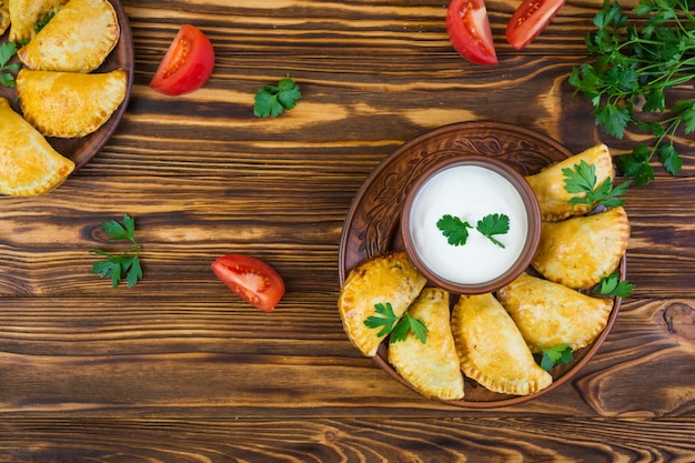 Delicious baked empanadas on wooden background