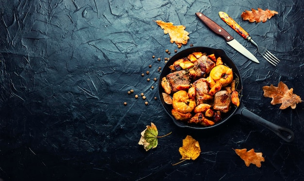 Delicious baked meat with aromatic autumn quince in iron cast pan.Copy space