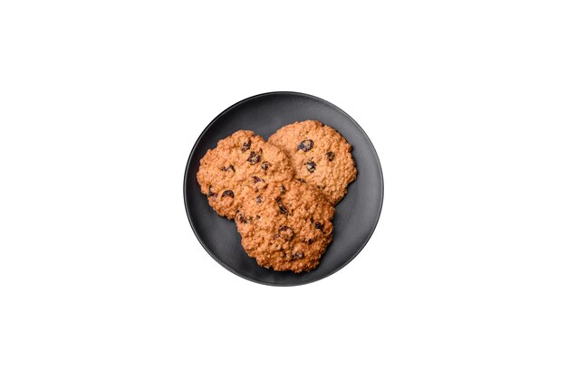 Delicious baked oatmeal raisin cookies on a dark concrete background Sweets for breakfast
