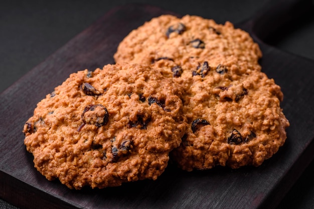 Deliziosi biscotti all'uvetta di farina d'avena al forno su uno sfondo di cemento scuro