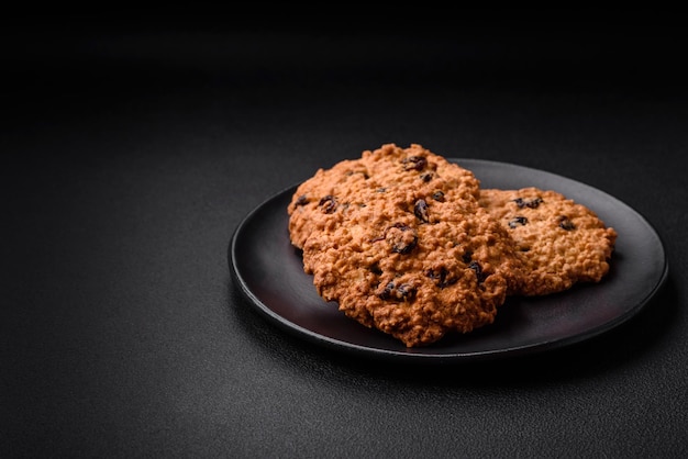 Deliziosi biscotti all'uvetta di farina d'avena al forno su uno sfondo di cemento scuro