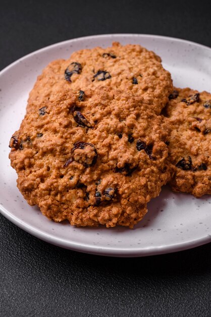 Deliziosi biscotti all'uvetta di farina d'avena al forno su uno sfondo di cemento scuro