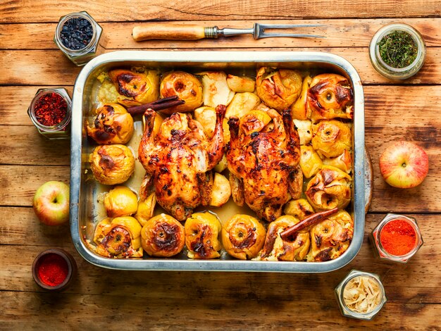 Delicious baked partridge with apples in an iron tray.