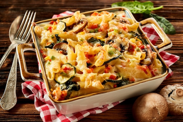 Delicious baked pasta in casserole on wooden table