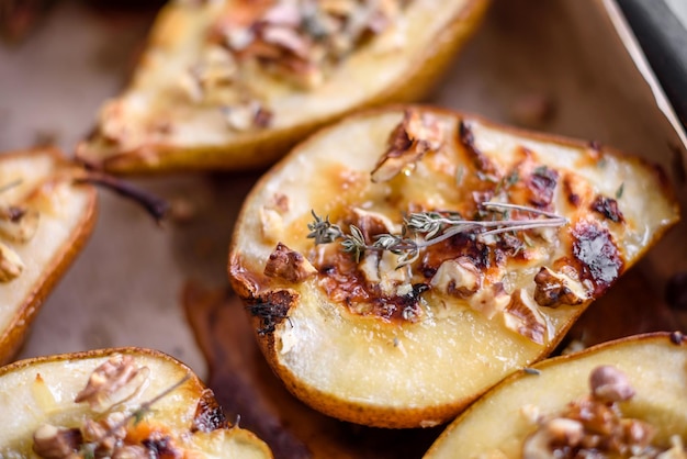 Delicious baked pear with dorblu cheese walnut and honey on a textured concrete background