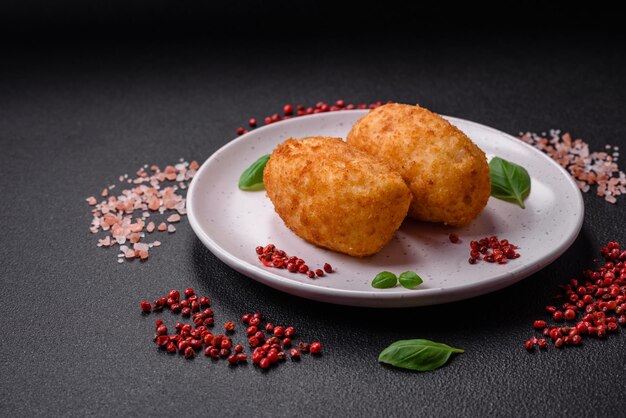 Delicious baked potato cutlet stuffed with chicken and vegetables spices and salt on a dark concrete background