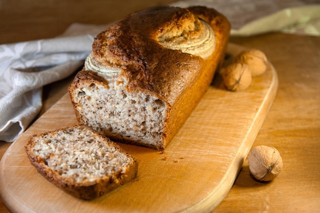 Вкусный банановый хлеб с орехами, нарезанными на деревянной доске