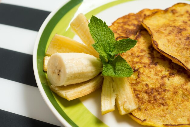 Delicious banana pancakes on a plate with green mint