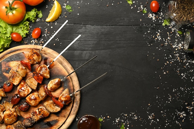 Delicious barbecue skewers with grilled chicken cherry tomato sweet pepper and onions black rustic wooden table