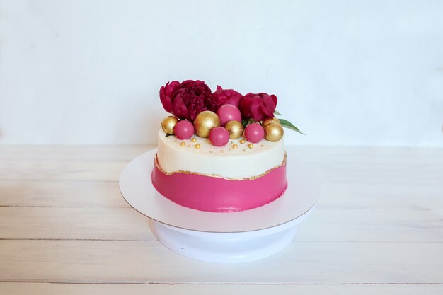 牡丹の花とカラフルなチョコレートで飾られた美味しくて美しい誕生日やウエディングケーキ