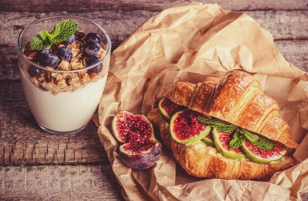 Delicious beautiful breakfast croissant with figs and yogurt with berries