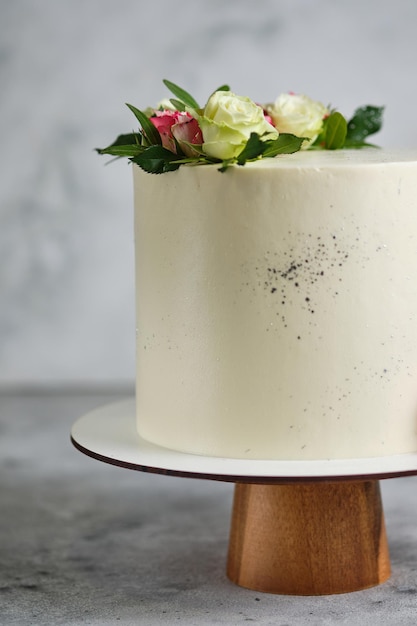 맛있고 아름다운 수제 케이크. 웨딩 과자. 화이트 케이크는 천연 장미 꽃으로 장식되어 있습니다.