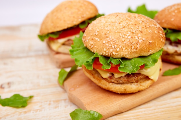 Delicious beef burgers on wooden table