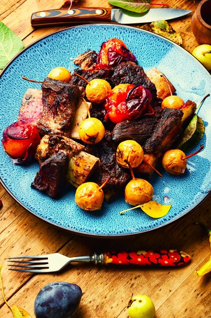 Delicious beef ribs roasted in plums and pears.Meat ribs in fruit