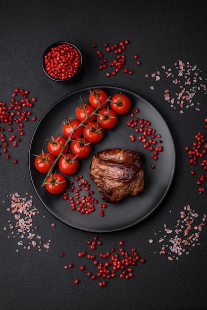 Delicious beef steak with salt spices and herbs on a ceramic plate