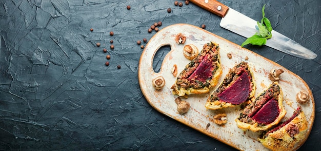 Delicious beetroot pie sliced on a kitchen board.Wellington pie.