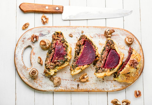 Delicious beetroot pie sliced on a kitchen board.Wellington pie.