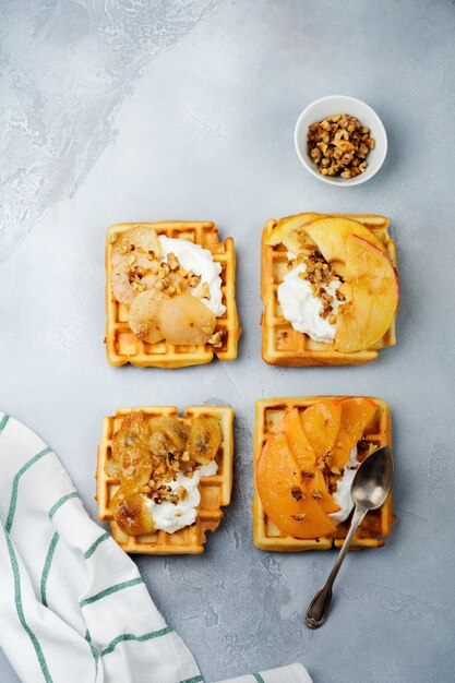 Photo delicious belgian wafers with caramelized apple and pear and walnuts