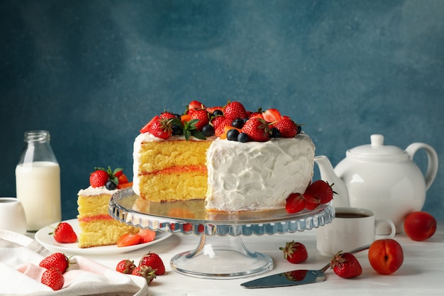 delicious berry cream cake on white wooden table