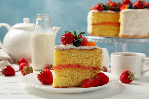 delicious berry cream cake on white wooden table