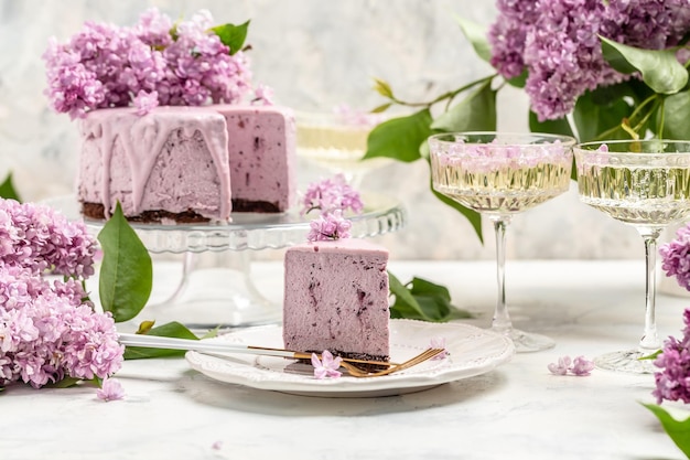 Photo delicious berry mousse cake with prosecco champagne wine bouquet of purple blooming lilacs french cuisine postcard background