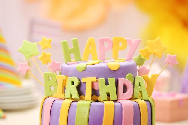 Delicious birthday cake on table on bright background