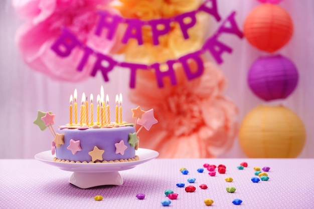 delicious birthday cake on table on bright background