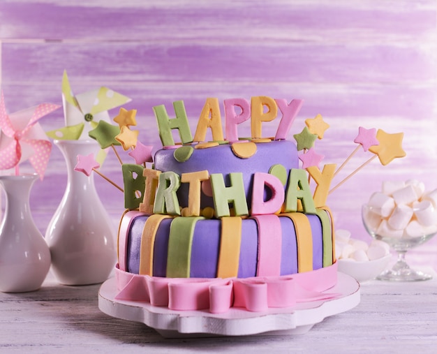 Delicious birthday cake on table on wooden background