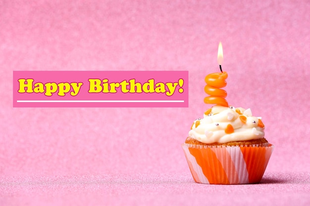 Delicious birthday cupcake on pink background