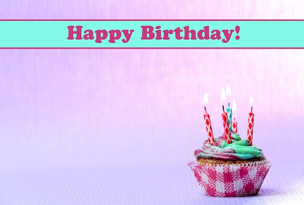 delicious birthday cupcake on table on light background