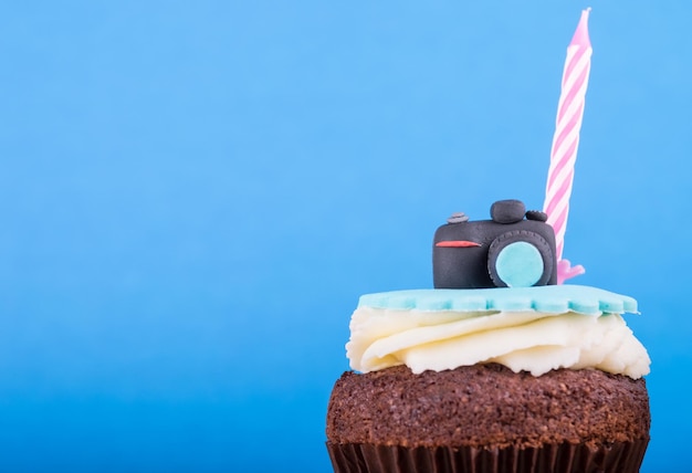 Delicious birthday cupcake with realistic camera icon on it