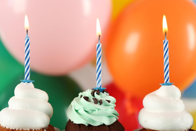 Delicious birthday cupcakes on bright background