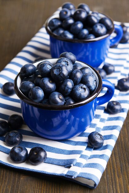 Delicious blueberries in cups on table close-up