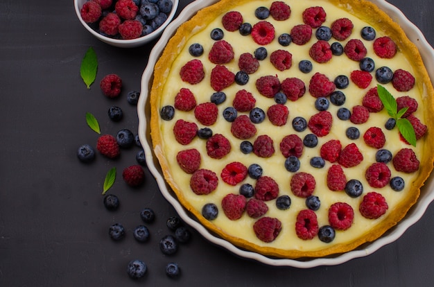 Tortino delizioso di mirtilli e lamponi con crema alla vaniglia