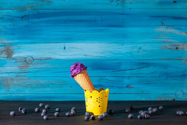 Вкусный рожок черничного мороженого на старой деревянной синей стене